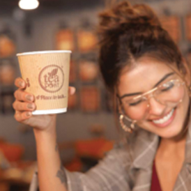 Woman holding a tea cup with a Tea Post logo on it.